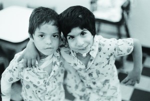 Black and white photo of two young boys with disabilities. Foto de dos amigos con discapacidades.