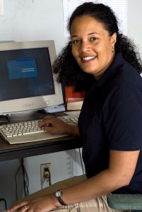 Una mujer sentado enfrente de la computadora.
