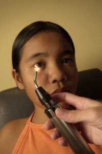 A youngster getting her eyes examined. Una joven recibe una examinacion de sus ojos.