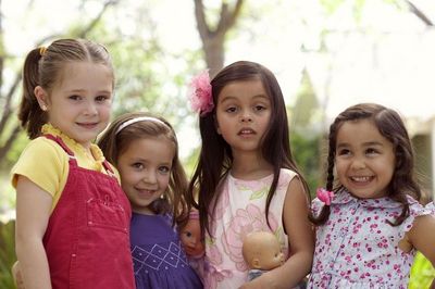 Foto de cuatro niñas. Four preschool-aged girls, giggling together.