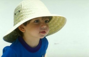 Foto de un niño de dos años, llevando un sombrero enorme.
