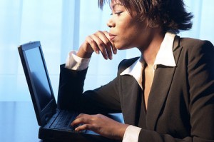 Picture of a woman at a laptop, serving in the role of the representative of the school system.