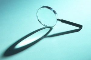 Closeup of a magnifying glass and its shadow.