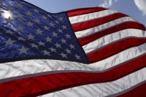 Closeup of the US flag, with a bit of blue sky behind.