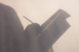 A hazy image of a person writing.