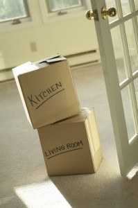 Photo of 2 moving boxes in an empty doorway, labeled "kitchen" and "living room."