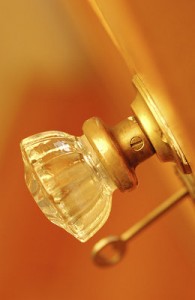 Closeup of a doorknob, with a key in the lock.