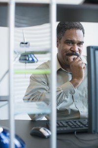 A man looks at his computer screen with concentration.