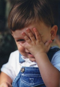 Photo of a 2-year-old boy covering one eye.