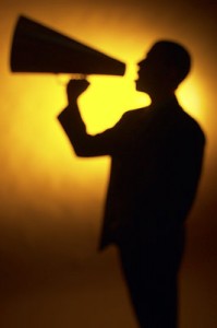 A man with a megaphone, announcing something far and wide.