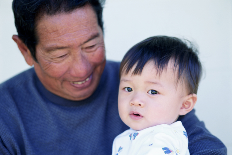 baby sits on grandad's lap