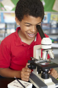 Student in science class looking through a microscope