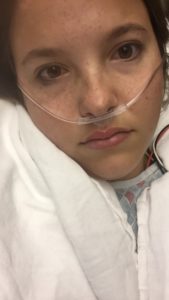unhappy young woman with oxygen hook up, looking at camera
