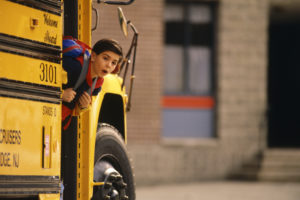 School bus arrives, student sticks his head out the door, getting ready to exit