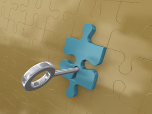 Photo of a key unlocking a piece of a puzzle