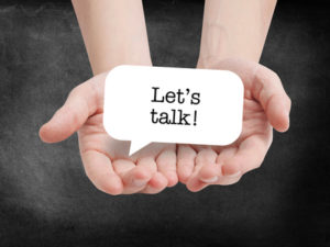 Hands cupping a sign that says Let's Talk