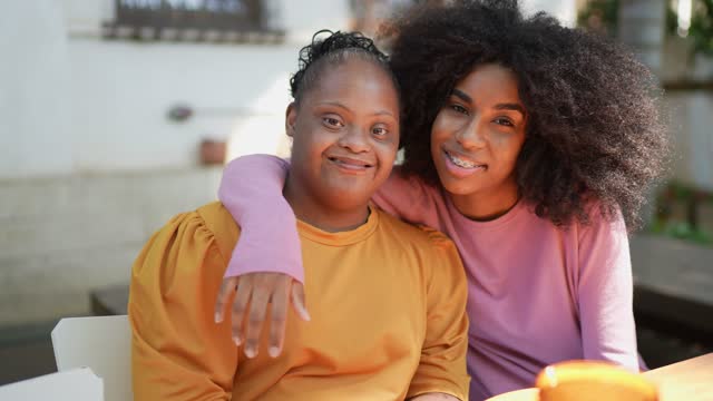 Young woman with down syndrome with sister Young woman with down syndrome with sister