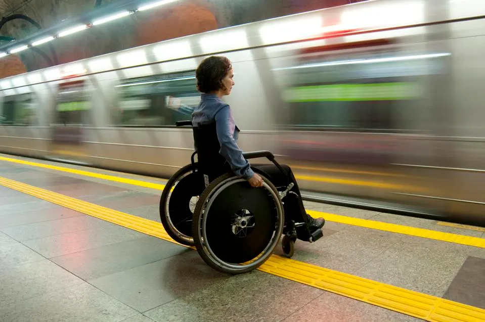 person in wheelchair in subway platform waiting for train person in wheelchair in subway platform waiting for train