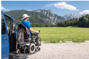 Man in a wheelchair looking at mountains in the distance.