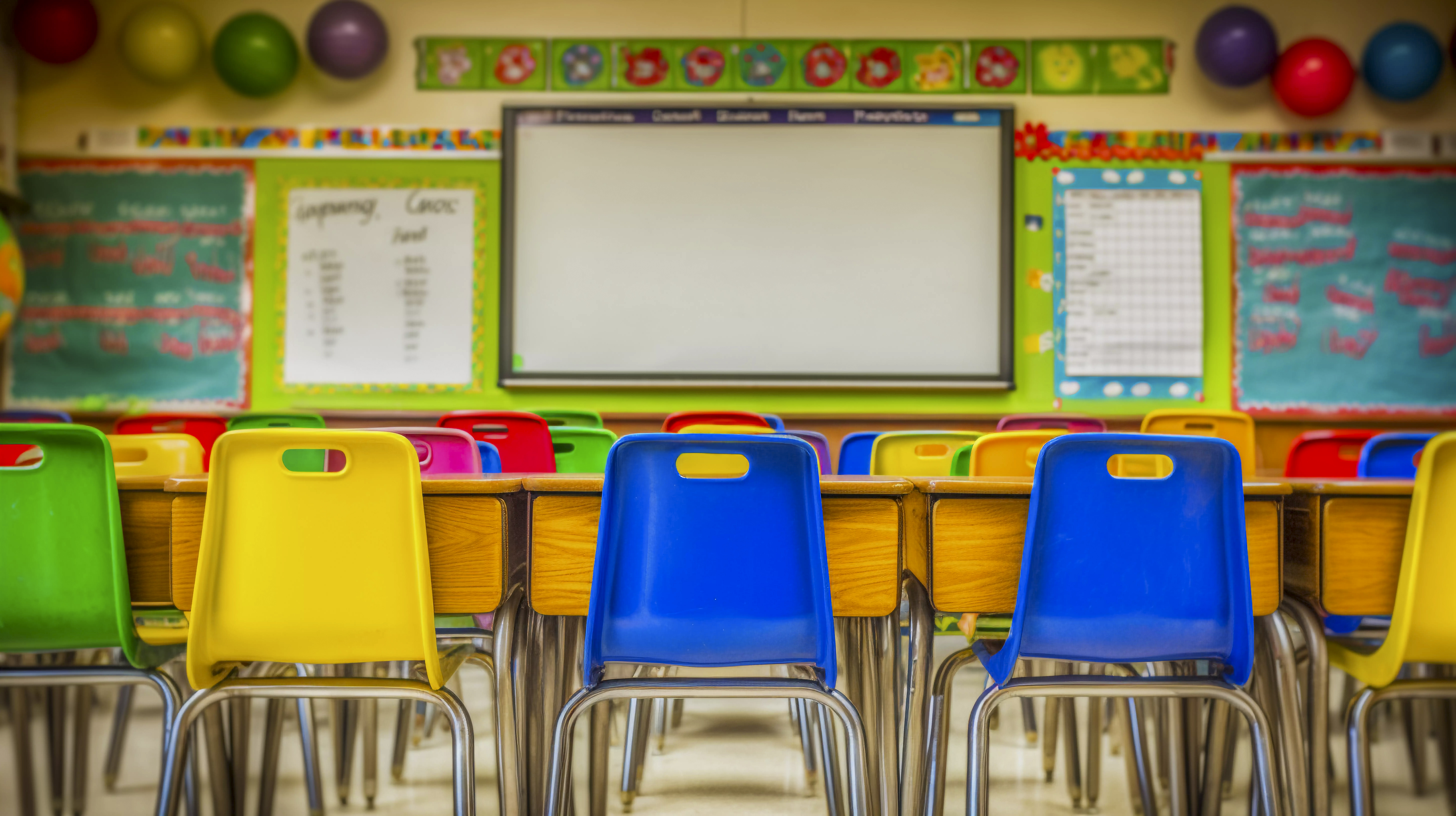 classroom with chairs and tables facing white board