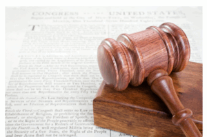 Picture of gavel laying on top of a page with text. 