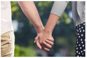 Picture with two people holding hands.