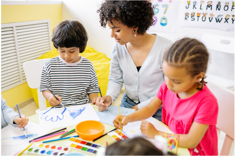 Teacher with two children doing crafts.