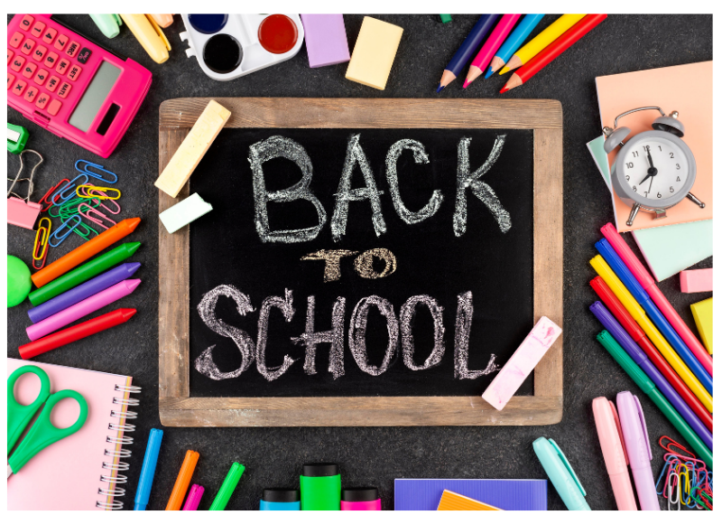 Image of a small chalkboard with the words back to school. School material surrounding the blackboard.