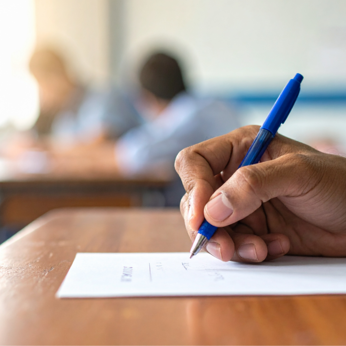 Image of hand writing with a blue pen.