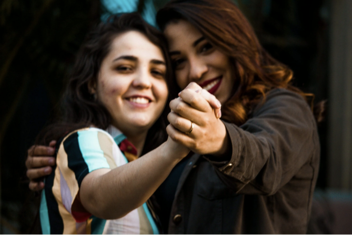 Image of mother and daughter looking at the camera while dancing.